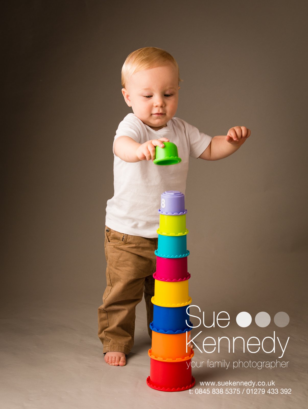 toddler boy building up a set of stacking cups
