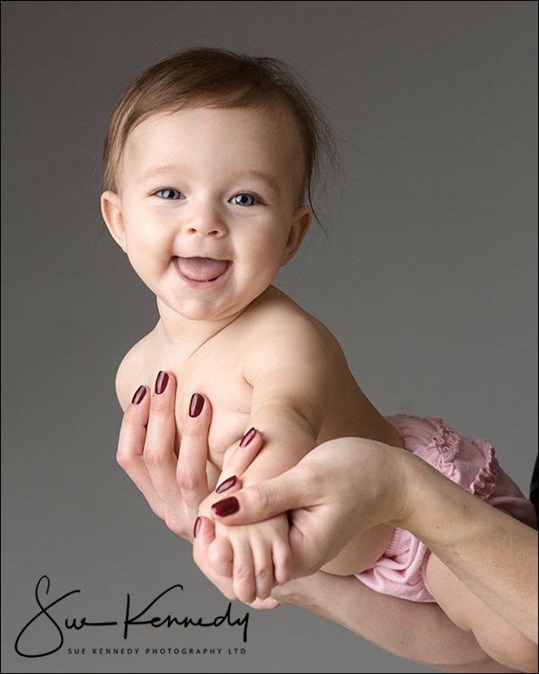 Baby girl in mums arms smiling