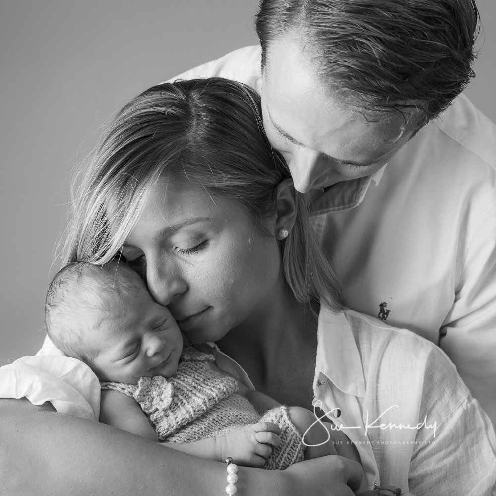 Black & white photograph of new parents from Broxbourne, holding their new baby