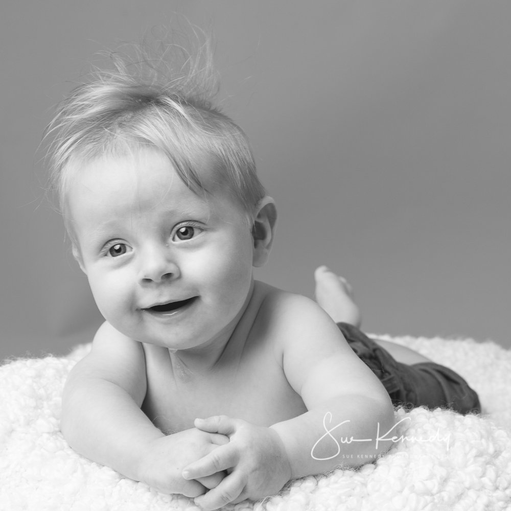 baby on tummy lifting head and smiling