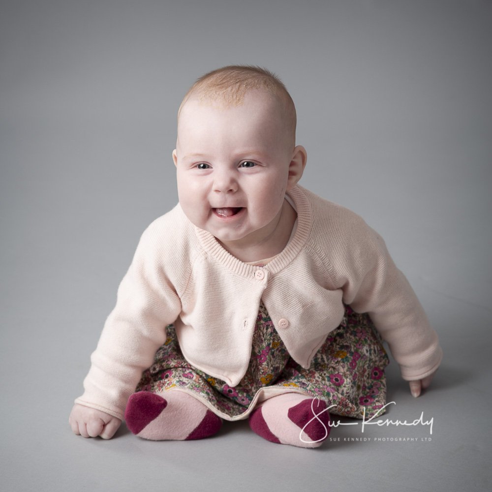 sitting baby smiling and leaning forward