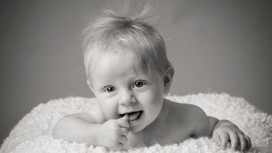 Young baby 3-4 months old pushing up on tummy looking towards camera