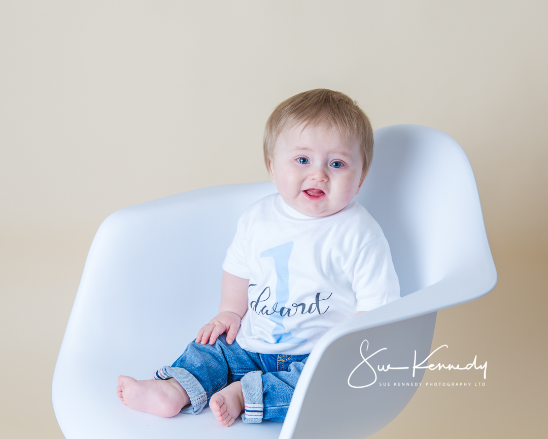 Baby boy sitting on white chair for his quick take studio portrait