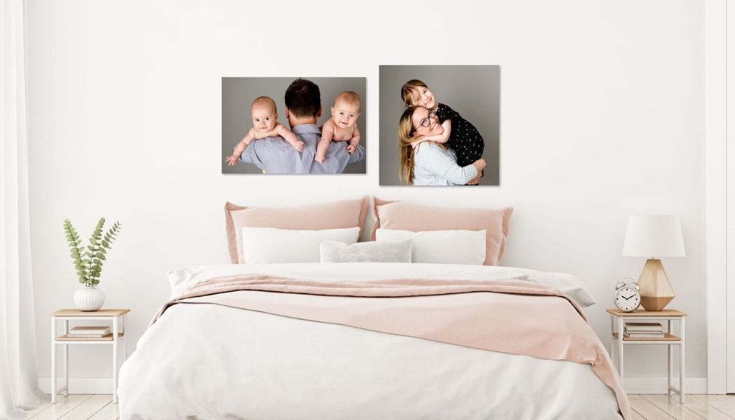 bedroom with wall portraits above the headboard of a family