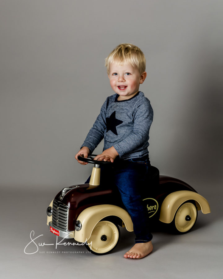 little boy sat on push along car