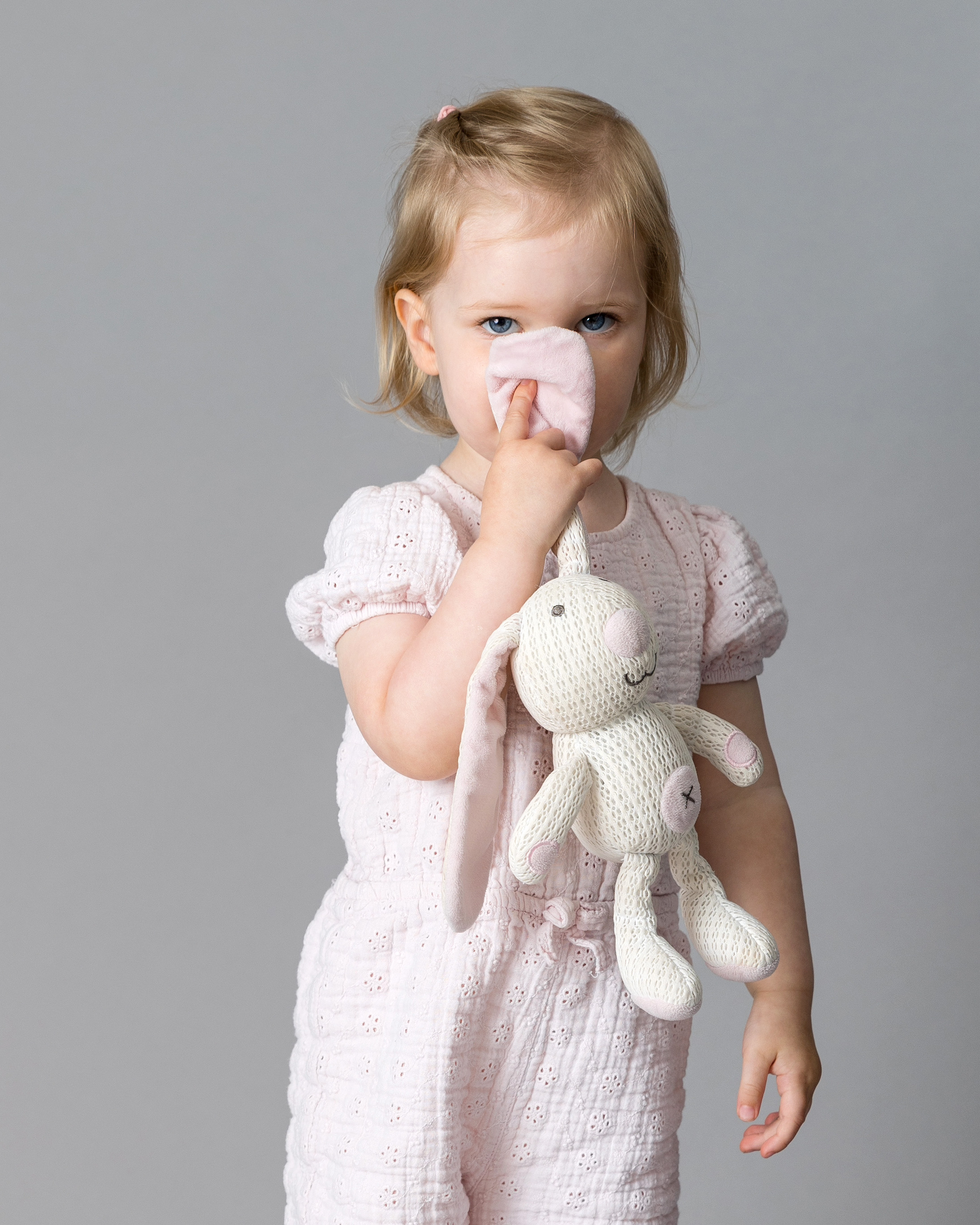 Toddler girl holding her favourite soft toy during a relaxed portrait session at Sue Kennedy’s Harlow studio, showing her gentle personality and quiet confidence.
